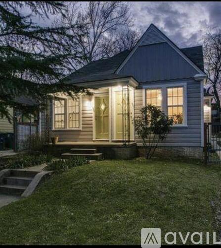 A house with a front porch and lights on.