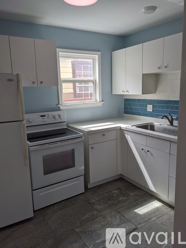 A kitchen with white appliances and cabinets.