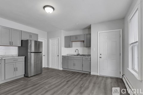 A kitchen with wooden floors and white walls.