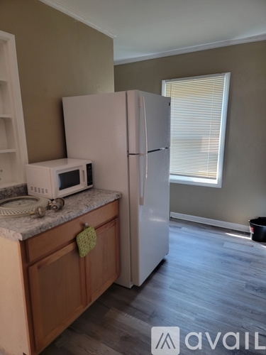 A kitchen with a white fridge and a white microwave on a counter.