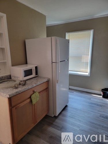 A kitchen with a white fridge and a white microwave on a counter.