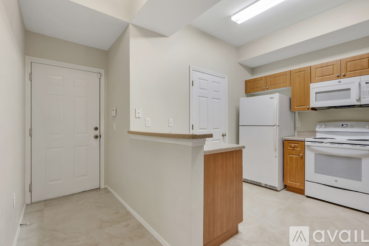 A kitchen with white appliances and wooden cabinets.