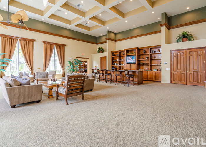 A spacious living room with a variety of seating options and a large entertainment center.