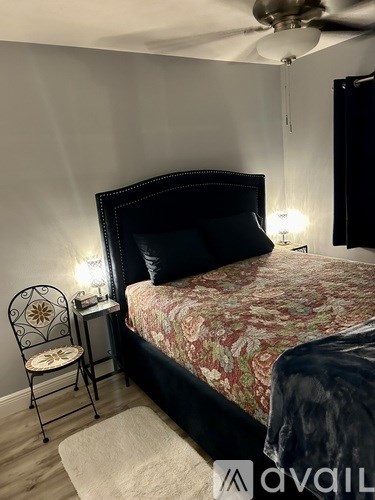 A bedroom with a floral bedspread and a white dresser.