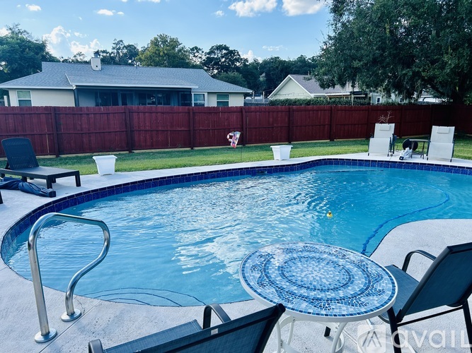 A pool with a blue tile table and chairs.