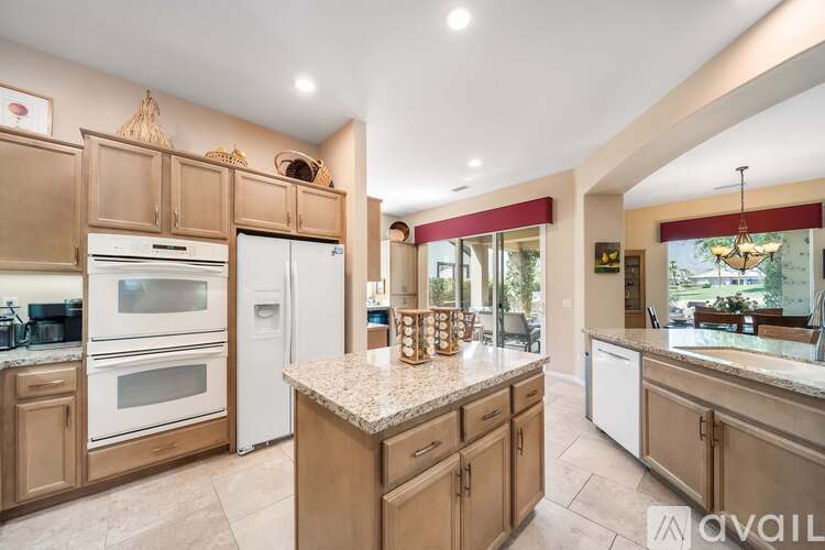 A kitchen with wooden cabinets and a marble countertop.