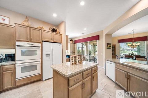 A kitchen with wooden cabinets and a marble countertop.