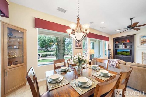 A dining room with a wooden table set for a meal.