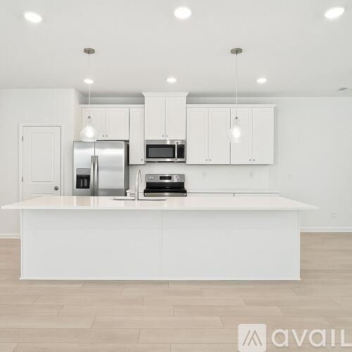 A modern kitchen with white cabinets and appliances.