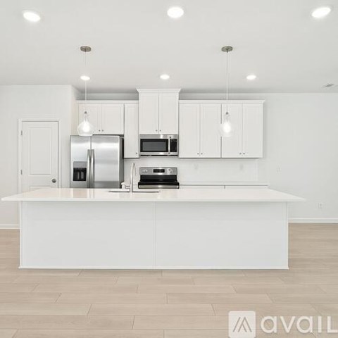 A modern kitchen with white cabinets and appliances.