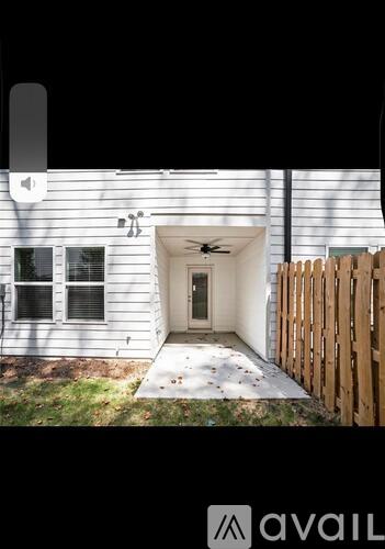 A house with a white exterior and a wooden fence.
