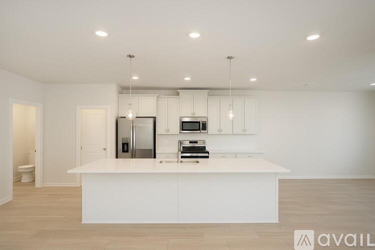 A modern kitchen with white cabinets and appliances.