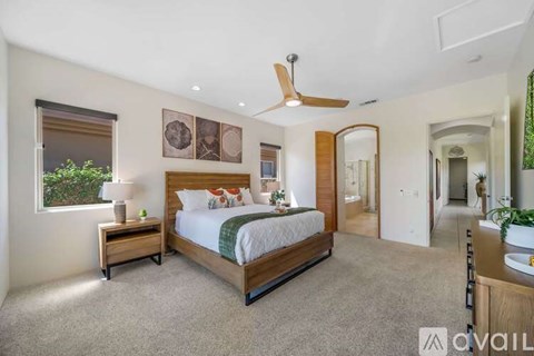 A bedroom with a large bed and a ceiling fan.