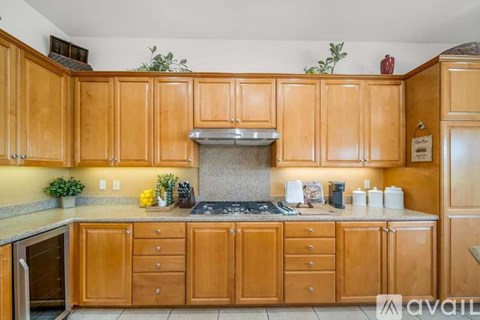 A kitchen with wooden cabinets and a stove top oven.