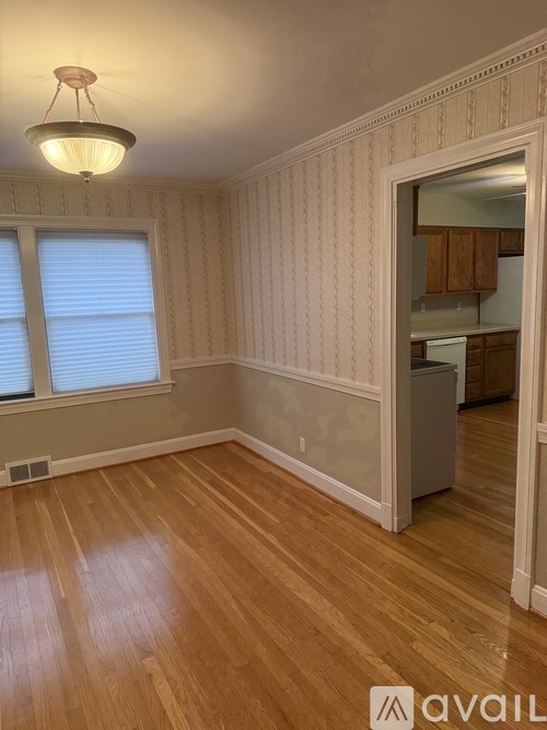 A room with wooden floors and a window with blinds.