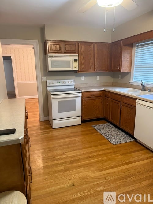 A kitchen with wooden cabinets and a white stove top oven.