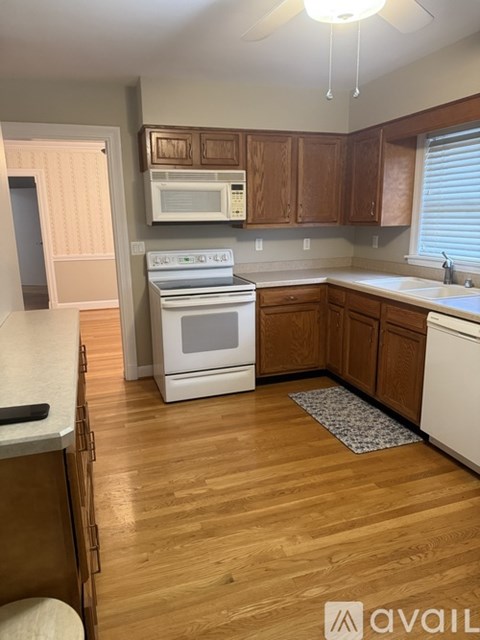 A kitchen with wooden cabinets and a white stove top oven.