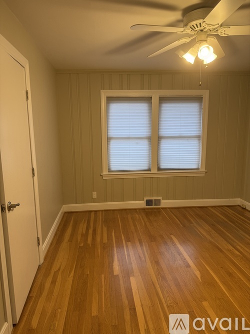 A room with wooden floors and a ceiling fan.
