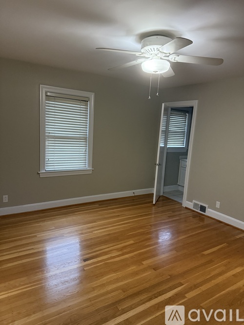 A room with a ceiling fan and wooden flooring.