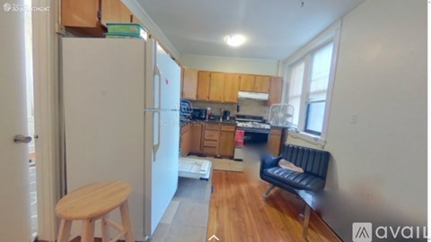 A kitchen with wooden cabinets and a black couch.