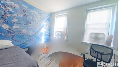 A room with a bed, a chair, and a desk.