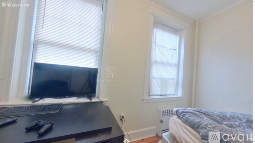 A room with a bed, a desk with a computer, and a window with blinds.