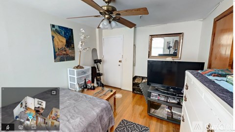 A bedroom with a bed, dresser, and a ceiling fan.
