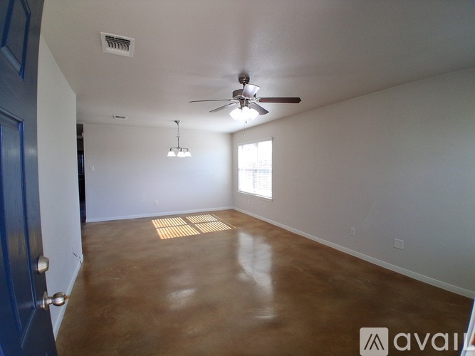 A room with a ceiling fan and a door.