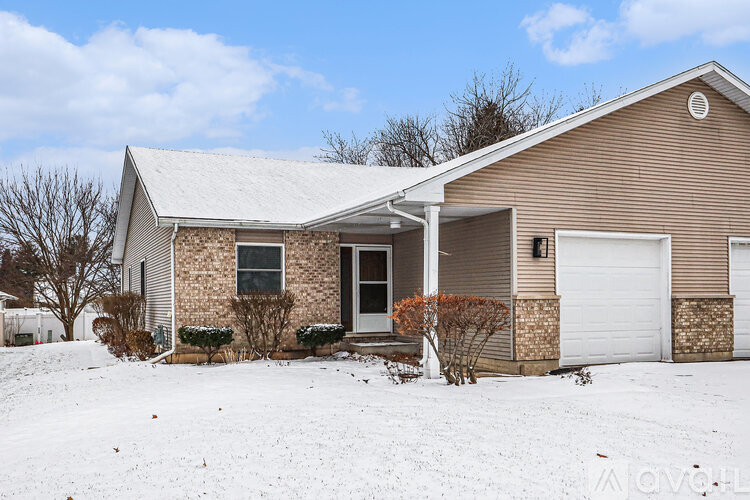 A house with a white garage door and a brown roof.