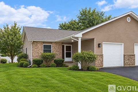 A house with a white garage door and a brown roof.