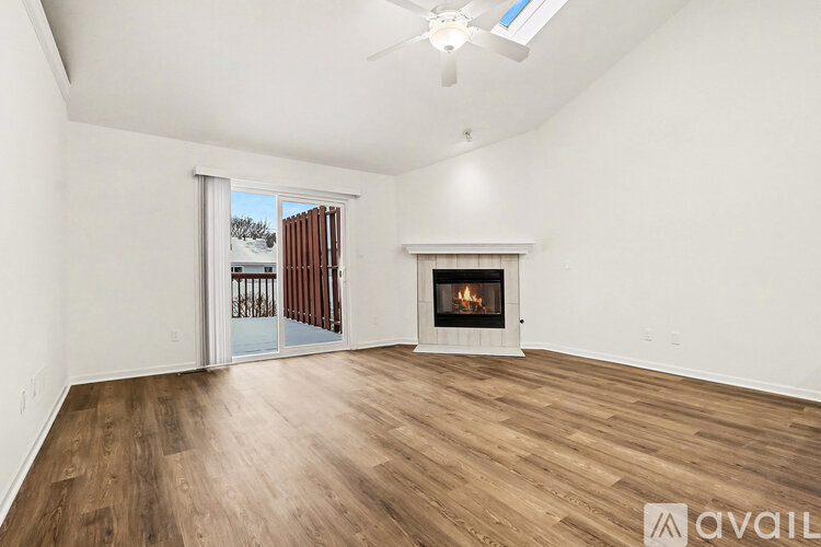 A spacious room with a fireplace and a ceiling fan.