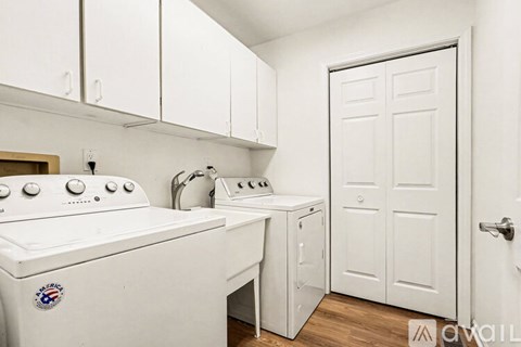 A white kitchen with a washing machine and a stove.