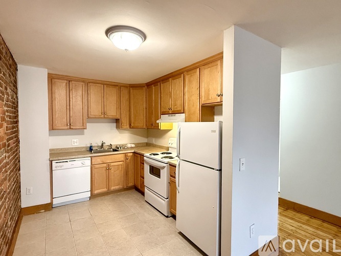 A kitchen with wooden cabinets and white appliances.