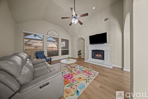 A living room with a grey sofa and a fireplace.