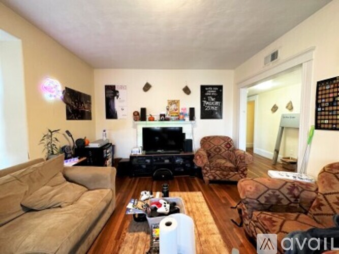A living room with a couch, chair, and television.