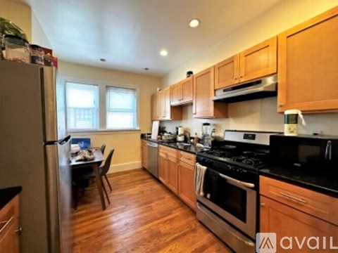 A kitchen with wooden cabinets and black countertops.