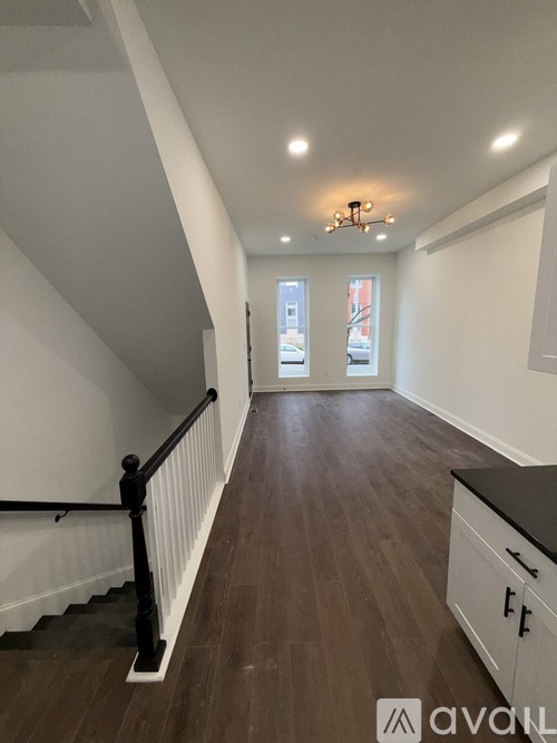 A long hallway with wood floors and white walls.