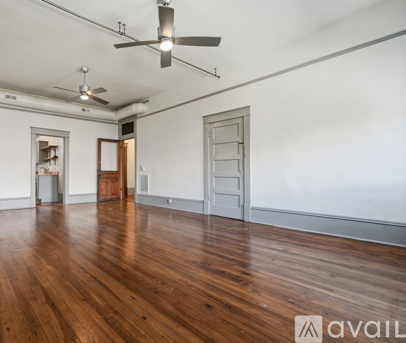 A room with wooden floors and a ceiling fan.