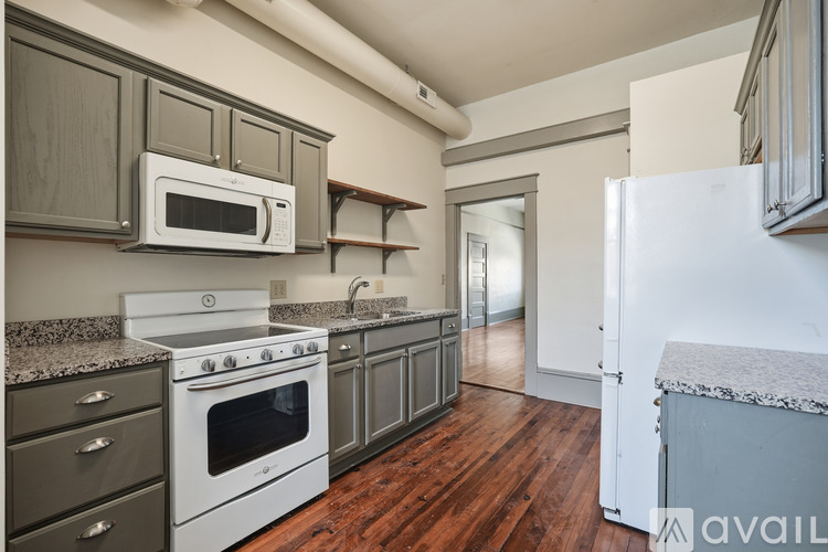 A kitchen with a white stove top oven and microwave, and a white refrigerator.