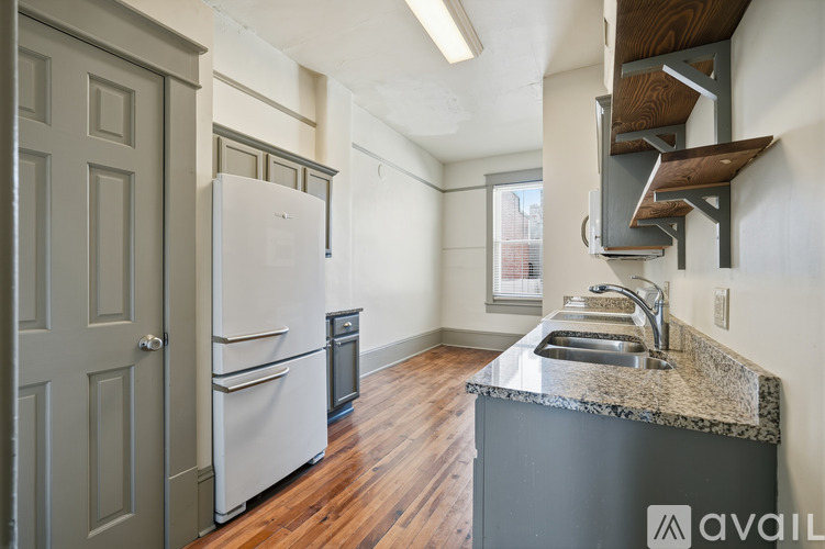 A kitchen with a white fridge and a sink.