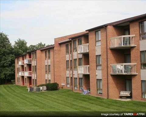 Apartment building with red brick and white balconies.