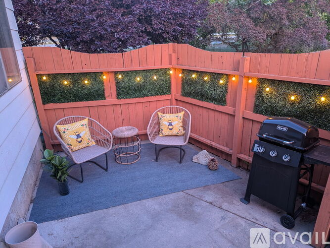 A patio with a table, chairs, and lights.
