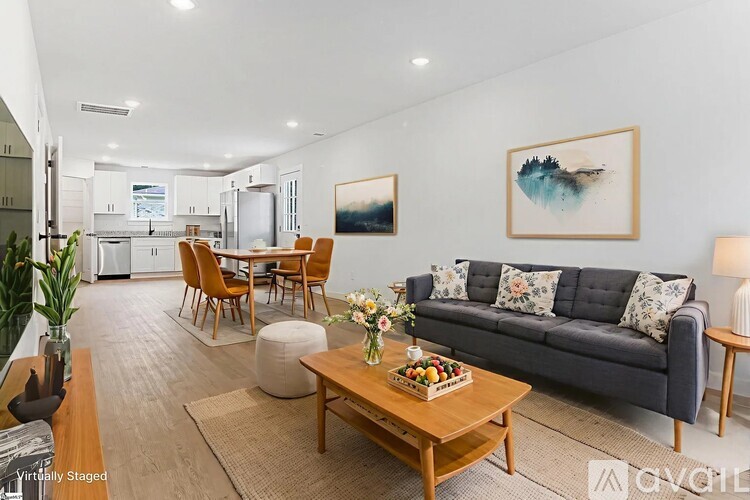 A modern living room with a grey sofa, wooden coffee table, and a painting on the wall.