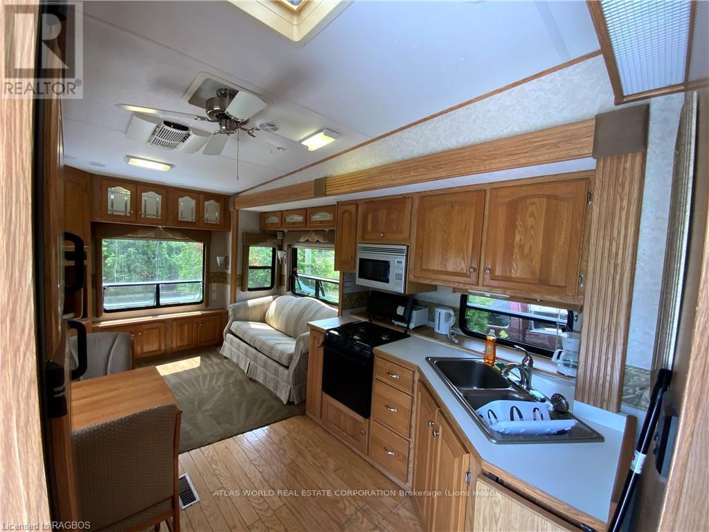 A well-lit kitchen area with wooden cabinets and a black stove top oven.