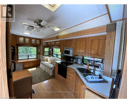 A well-lit kitchen area with wooden cabinets and a black stove top oven.