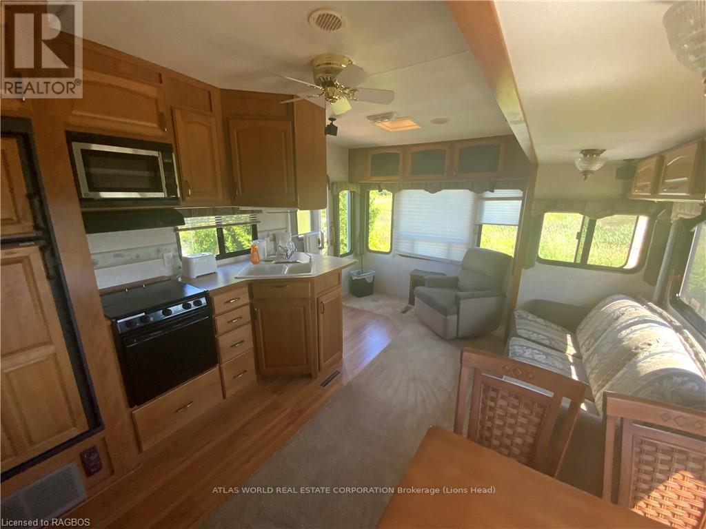 A kitchen area with wooden cabinets and a black stove top oven.