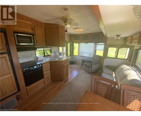 A kitchen area with wooden cabinets and a black stove top oven.