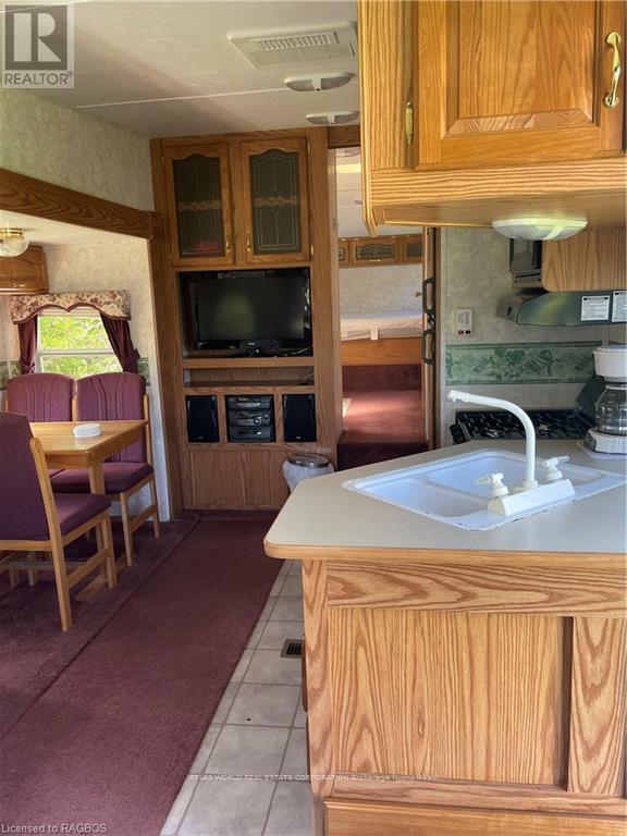 A kitchen with wooden cabinets and a white sink.