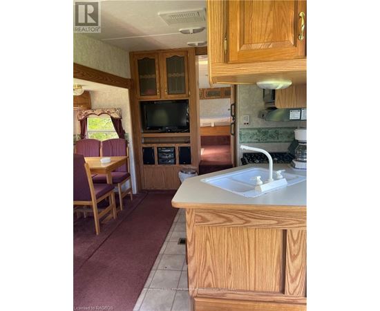 A kitchen with wooden cabinets and a white sink.