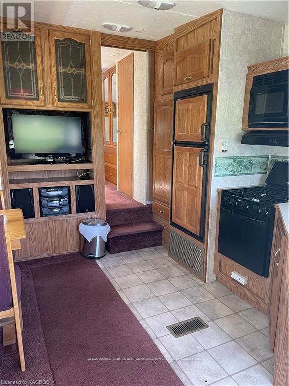 A kitchen with wooden cabinets and a black stove top oven.